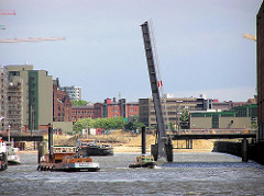 Die Sandtorhafenklappbrücke ist geöffnet, Arbeitsschiffe fahren im Sandtorhafen - im Hintergrund die Bauarbeiten zu den Magellan Terrassen (2004)