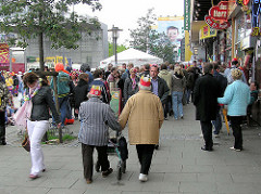 Passanten auf dem Spielbudenplatz / Reeperbahn Hamburg St. Pauli - re. Gewerbe / Läden, die zum Areal der Essohäuser gehören.