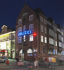 Hamburgs bekannteste Polizeiwache, die Davidwache in Hamburg St. Pauli. Fussgänger überqueren die Ampel.