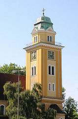 Kirchturm in Hamburg Wilstorf - ockerfarbener, gelber Anstrich, Kupferkuppel mit Kreuz - St. Franz-Joseph-Kirche, erbaut 1913.