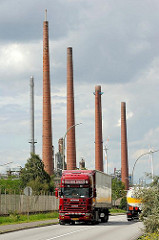 Schornsteine einer Erdölraffinerie in Hamburg Wilhelmsburg - Lastwagen auf der Strasse.