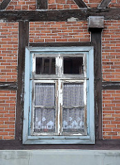 Historisches Harburger Fachwerkgebäude, restaurierungsbeduerftiges Holzfenster.