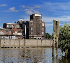 Billehafen in Hamburg Rothenburgsort - Alte Holzdalben im Wasser. Backsteinkontorhaus am Brandshofer Deich - Hamburger Architekturgeschichte.