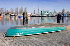 Blick über den Überwinterungshafen in Hamburg Harburg - ein Ruderboot liegt auf dem Ponton in der Sonne; im Hintergrund das Polizeigebäude der Wasserschutzpolizei - Wasserschutzpolizeikommisariat 3.