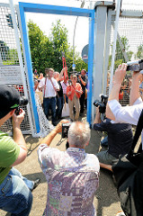 Die Stadtentwicklungssenatorin Anja Hajduk und Bezirksamtsleiter Markus Schreiber posieren mit Bolzenschneider für die Presse - der Durchgang durch den Zollzaun am Spreehafen in Hamburg Wilhelmsburg ist geöffnet worden. (2010)
