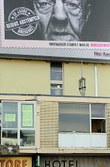 Fassade / Fenster am Spielbudenplatz in Hamburg St. Pauli, Instandhaltung -  Kein Abriss Essohäuser. Fassadenwerbung für Hinz & Kunzt - 20 Jahre gegen Abstempeln.