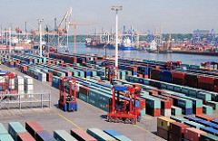 Gelände des Containerlagers Terminal EUROGATE - Van Carrier fahren durch die Reihen der Container. Auf der anderen SEite des Hafenbeckens das HHLA Container Terminal Burchardkai.