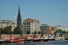 Barkassen liegen im Zollkanal vor den Kajen - im Hintergrund das Haus der Seefahrt und der Turm der ehemaligen Nikolaikirche Hamburer Innenstadt.