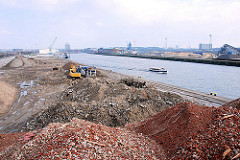 Berge Bauschutt der abgerissenen Gebäude am Versmannkai / Baakenhafen - eine Barkasse der Hamburger Hafenrundfahrt fährt Richtung Elbe.