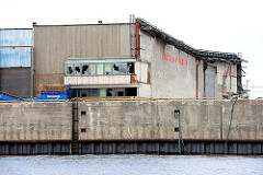 Abrissgebäude am Kirchenpauerkai an der Norderelbe - die Scheiben eines Industrie-Gebäudes in der Hamburger Hafencity sind eingeworfen.