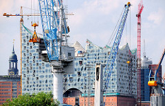 Hafenkräne vor der Baustelle der Elbphilharmonie in der Hamburger Hafencity.