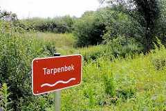 Schild des Baches Tarpenbek in Hamburg Niendorf - Wiesen am Ufer der Tarpenbek.