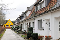 Reihenhäuser in Hamburg Hausbruch - im Hintergrund ein Einzelhaus mit gelber Fassade.