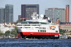 Das Kreuzfahrtschiff FRAM läuft aus dem Hamburger Hafen aus - im Hintergrund Hochhäuser von Hamburg St. Pauli.