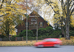 Ländliches Wohnhaus am Poppenbuettler  Weg - schnell fahrendes Auto.