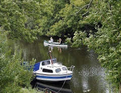 Dove-Elbe bei Hamburg Reitbrook - Sportboot am Ufer - Kanu auf dem Wasser des Hamburger Flusses.
