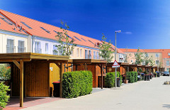 Neubauten in Hamburg Rönneburg - einstöckige Reihenhäuser - Carports aus Holz vor den Wohngebäuden.