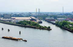 Luftaufnahme; Blick über die Norderelbe in den Moldauhafen auf dem Kleinen Grasbrook - lks. der Holthusenkai und Veddelhöft. Bilder aus dem Hafen Hamburgs - ein Schlepper zieht vier Schuten mit Stückgut.