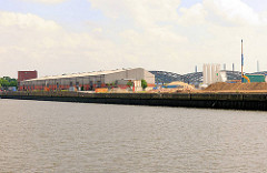 Baustelle und Lagergebäude beim Versmannkai / Baakenhafen - Kirchenpauerkai; im Hintergrund die Hamburger Freihafenelbbrücken über die Norderelbe.