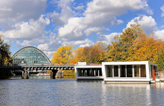 Hochwasserbassin Hamburg Hammerbrook -  Schwimmende Häuser, Hausboote - wohnen auf dem Wasser. Im Hintergrund das Bürogebäude Berliner Bogen; Herbstbäume, blauer Himmel - weisse Wolken.