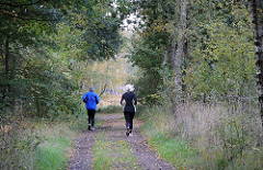 Jogger auf einem Waldweg im Duvenstedter Brook.