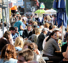 Sonnentag im Hamburger Stadtteil Sternschanze - Bewohner sitzen in der Sonne in Cafes und Restaurants auf der Strasse.