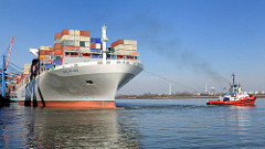Der Containerfrachter NYK HELIOS legt im Hamburger Hafen ab - Schlepper ziehen das riesige Containerschiff ins Fahrwasser und wenden den Frachter.