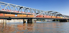 Eisenbahnbrücken über den Oberhafenkanal in der Hamburger Hafencity - ein S-Bahnzug und ein Güterzug mit Containern / Containerzug überqueren die Brücke. Im Hintergrund die Billhorner Brücke.