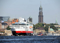 Das Kreuzfahrtschiff Fram verlässt den Hamburger Hafen - rechts die St. Pauli Landungsbrücken und die Hamburger St. Michaeliskirche.