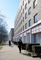 Renovierte Hausfassade und Geschäfte - Kleingewerbe; Wohnblock mit Ziegelfassade auf der Veddel im Hamburger Bezirk Mitte.