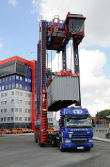 Containercarrier belädt einen Sattelschlepper auf dem Gelände des HHLA Container Terminals Tollerort.