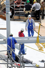 Bauarbeiter arbeiten im Juli 2013 auf dem Dach der Baustelle der Hamburger Elbphilharmonie - Eisenträger werden zusammengeschweisst.