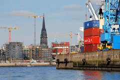 Blick aus dem Hansahafen über die Norderelbe zu den Baustellen am Grasbrookhafen der Hamburger Hafencity. Container am Kai - Turm der Nikolaikirche (2007)