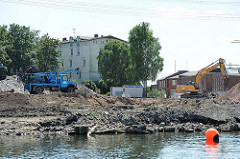 Baustelle am Überwinterungshafen - Harburger Schloss im Hintergrund - Bagger am Hafenufer.