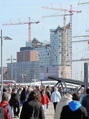 Spaziergänger_innen an der Überseebrücke; Baustelle der Elbphilharmonie und Bürogebäude am Kehrwieder der Hamburger Hafencity.