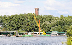 Blick über die Norderelbe zum Ponton des ehem. Zollanlegers in Hamburg Entenwerder - dahinter die Bäume vom Elbpark in Rothenbursort und die Spitze des Wasserturms.