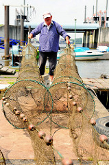 Fischfang im Hamburger Hafengebiet - die Reusen werden vom Fischer an Land ausgebreitet und geprüft.