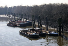 Leere Schuten / Lastkähne, Arbeitsschiffe an Dalben in Hamburg Wilhelmsburg, Klütjenfelder Hafen.