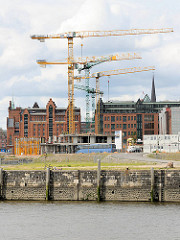Kaimauer am Versmannkai - Baukräne am Magdeburger Hafen in der Hafencity Hamburg - im Hintergrund der Kaispeicher B - das Maritime Museum Hamburg.