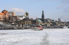 Eis auf der Elbe - eisbedecktes Wasser vor den Hamburger Landungsbrücken - Hafenfähre vor den St. Pauli Landungsbrücken.