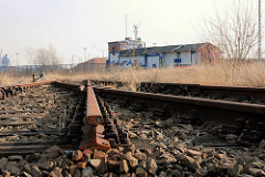 Stillgelegtes und abgetrenntes Bahngleis der Hamburger Hafenbahn - verlassenes Bahngebäude und Zollzaun an der Versmannstrasse am Baakenhafen.