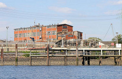 Industriegebäude mit Ziegelfassade - Rohre im Reiherstieghafen; Motive aus Hamburg Wilhelmsburg.