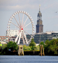 Blick über den Moldauhafen zum Riesenrad in der Hamburg Hafencity - rechts der Michel, die St. Michaeliskirche, dem Wahrzeichen Hamburgs.