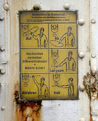 Schild am Kran an der Grossen Elbstrasse - Handzeichen im Kranbetrieb, Die Kranführer sind angewiesen nach diesen nur von einer Person zu gebenden Handzeichen zu fahren.