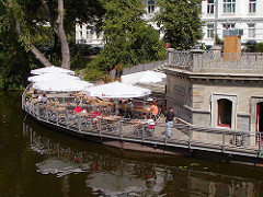 Restaurant / Cafe an der Mundburger Brücke; umgebaute Kasesmatten am  Mundsburger Kanal / Eilbekkanal. Tische und Sonnenschirme am Wasser.