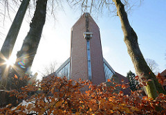 Die 2000 geweihte St. Marienkirche in Quickborn - Gegenlichtaufnahme, Herbstlaub an einer Buchenhecke.