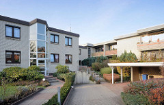 Neubauten mit verglasten Treppenhaus; Balkons in der Sonne - Carport / Architektur in Quickborn, Kreis Pinneberg.