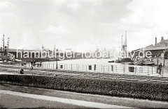 Blick in den Sandtorhafen Richtung Elbe / Kaispeicher A - links der Kaiserspeicher und rechts der Sandtorkai. Eine Familie mit Kinderwagen geht auf dem Kai. (ca. 1934)