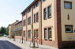 Zum Wohngebäude umgebaute Industriearchitektur  / Malchow, Mühlenstrasse; Auschrift Malchower Inselwohnsitz - Betreutes Wohnen.