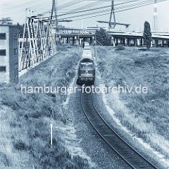 Güterzug mit Container verlässt den Hamburger Hafen - Containertransport auf der Schiene; im Hintergrund die Baustelle der Köhlbrandbrücke. (ca. 1972 )